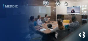 MEDDIC - Videoconferência entre um senhor de terno e gravata e várias pessoas que estão ao redor de uma mesa.