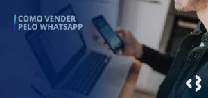 Como vender pelo WhatsApp - Homem sentado em frente a um notebook com um celular na mão.